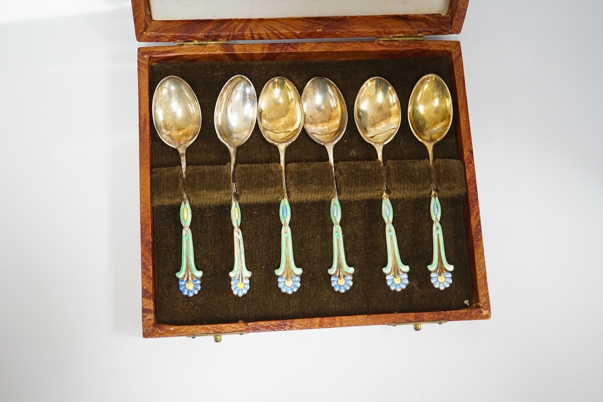 A cased harlequin set of six George VI silver gilt and three colour enamel set coffee spoons, Turner & Simpson, Birmingham, 1940,42 & 48, 89mm, enamel a.f. Condition - poor to fair